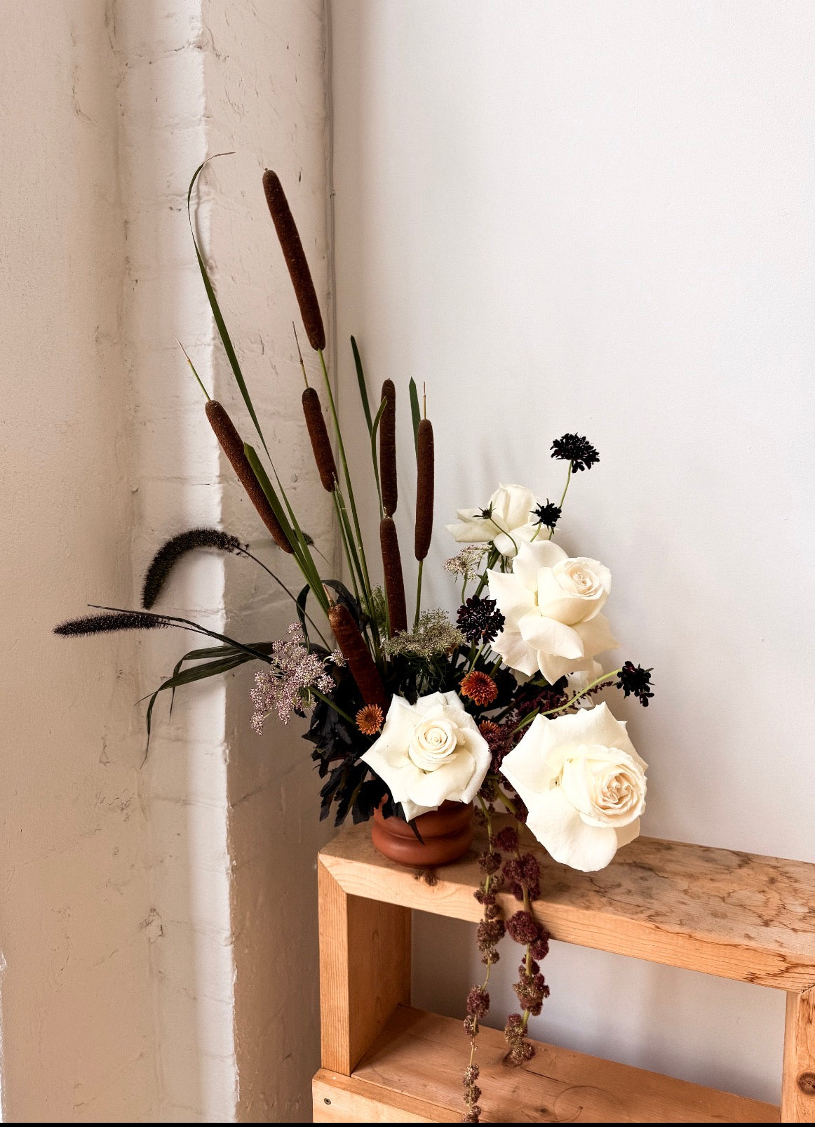 Terracotta Dusk autumn flower arrangement with white roses in a warm terracotta pot⠋

